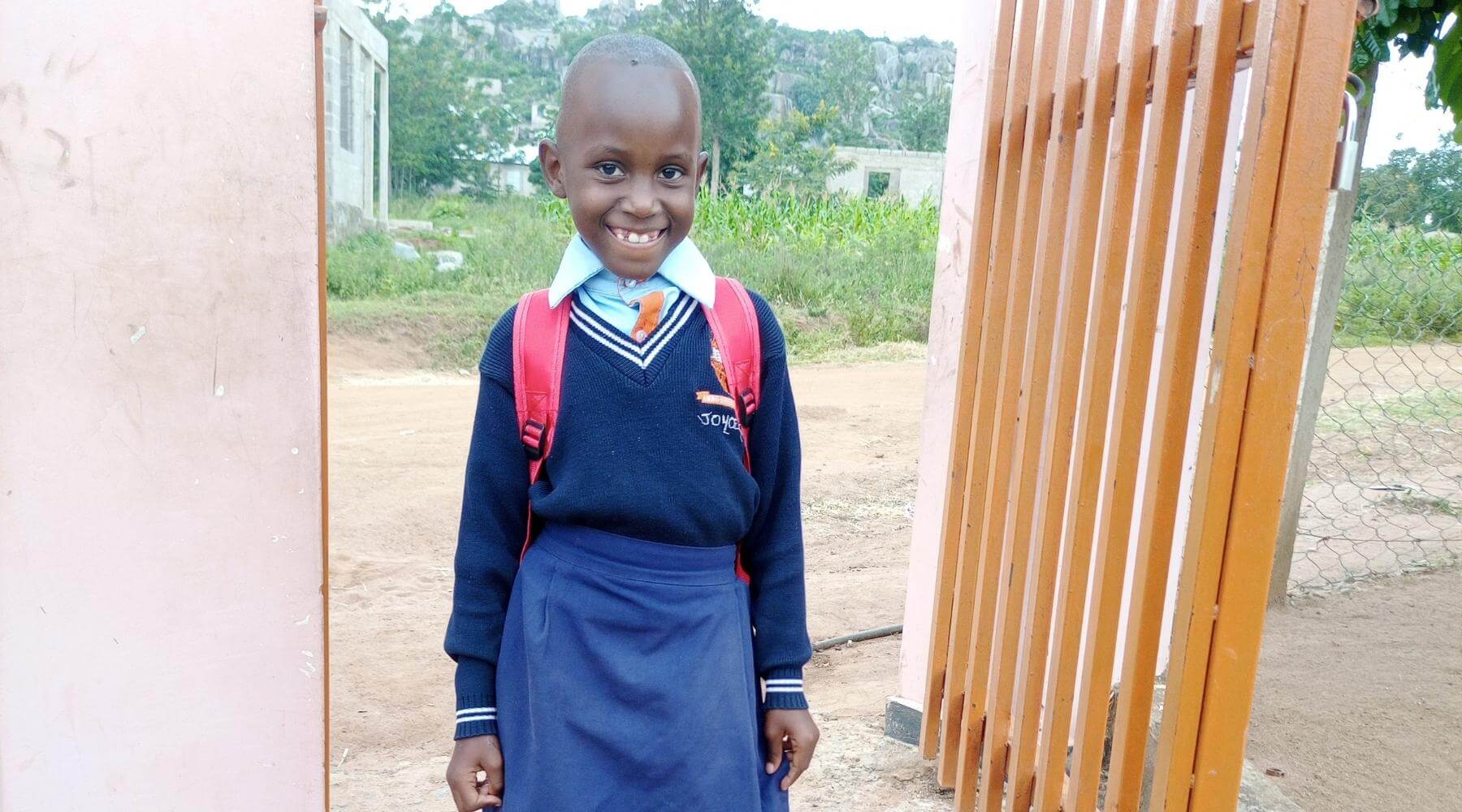 child smiling by school gate