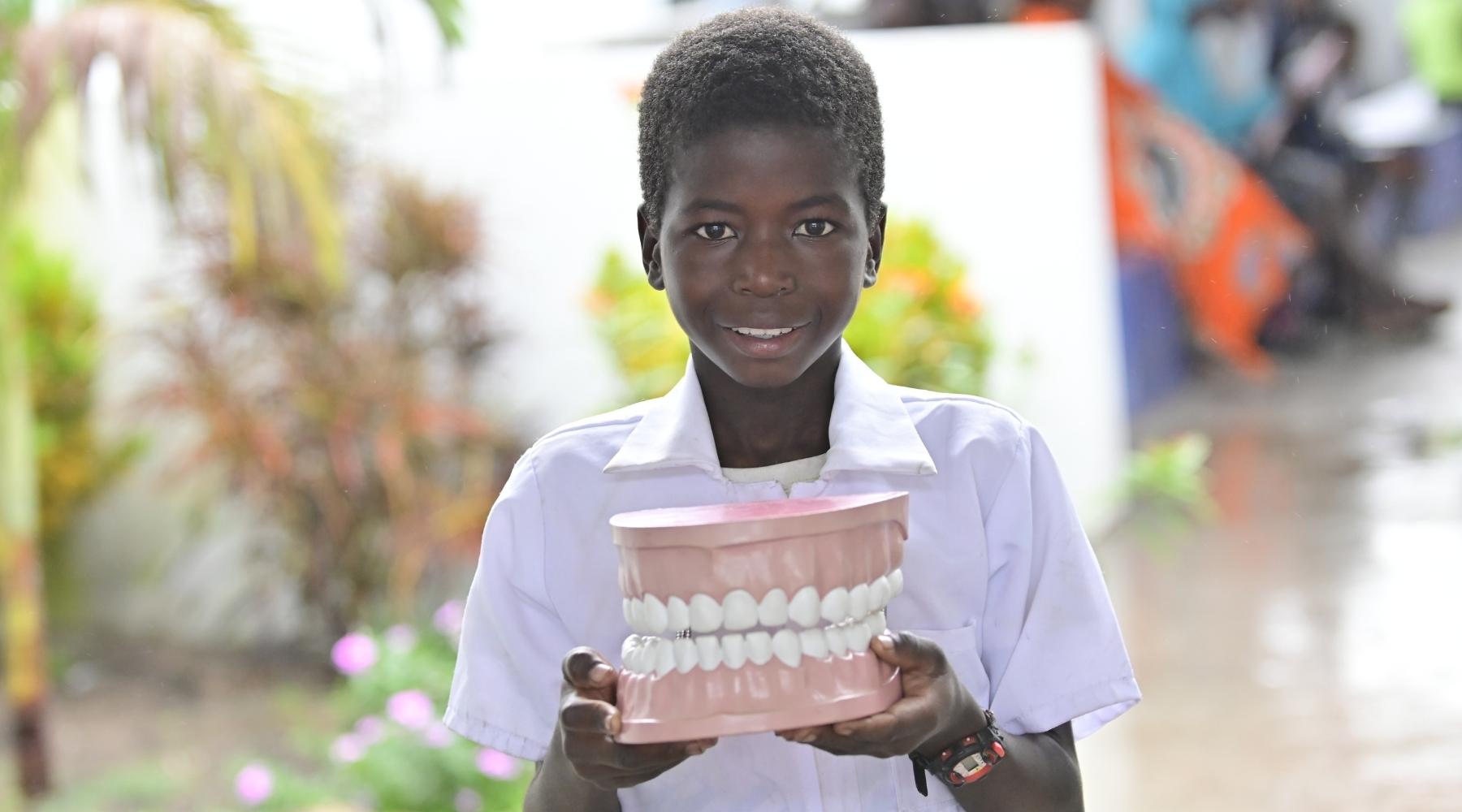 child holding fake teeth