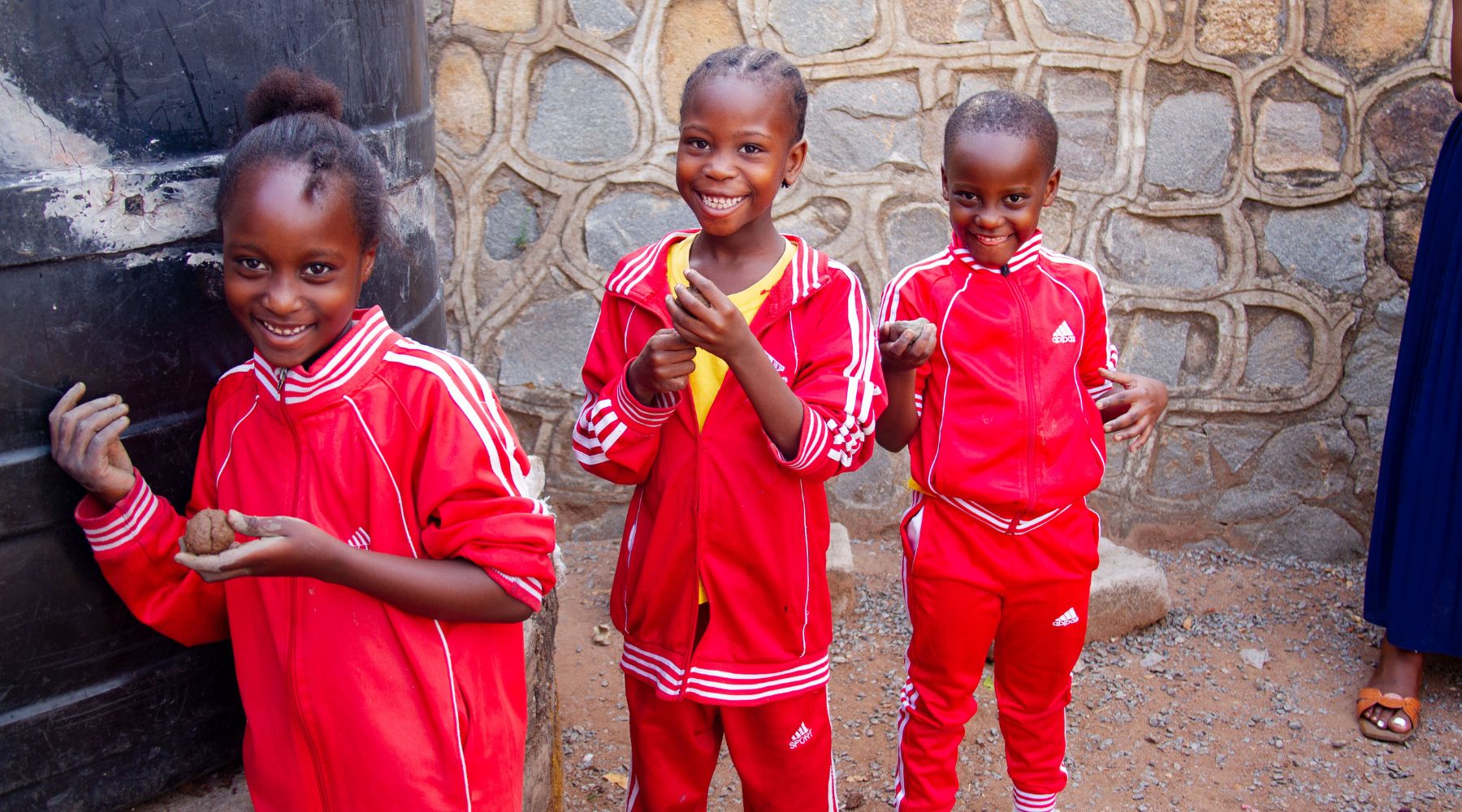 2024.10.28-mwanza three young children holding moulding clay and smiling