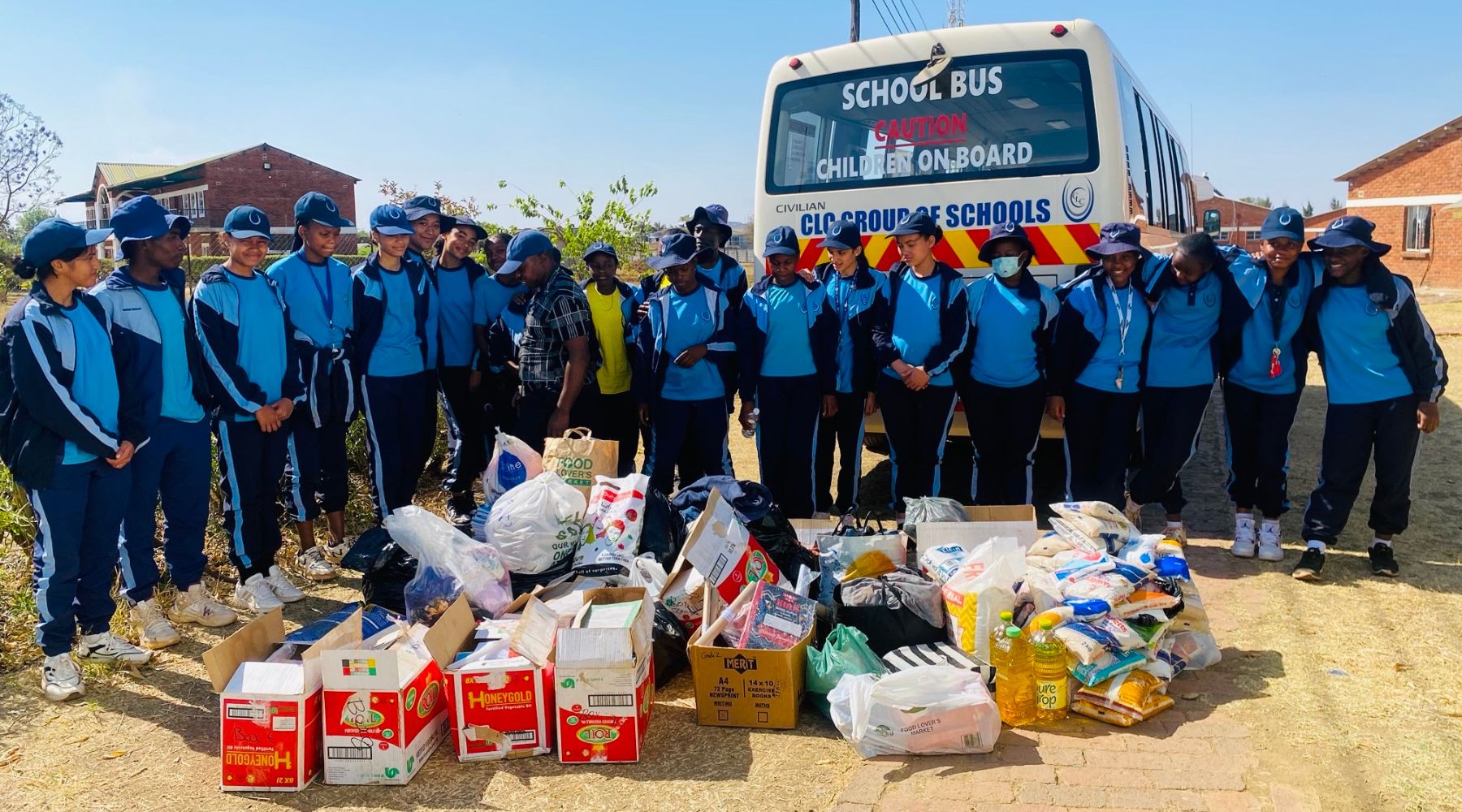 2024.10.28-zimbabwe A group of young people standing with a pile of food and other essential items