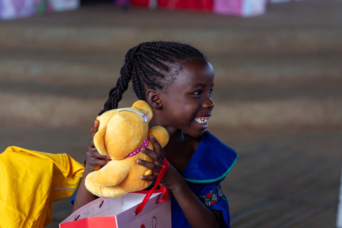 Girl holding teddy bear and smiling