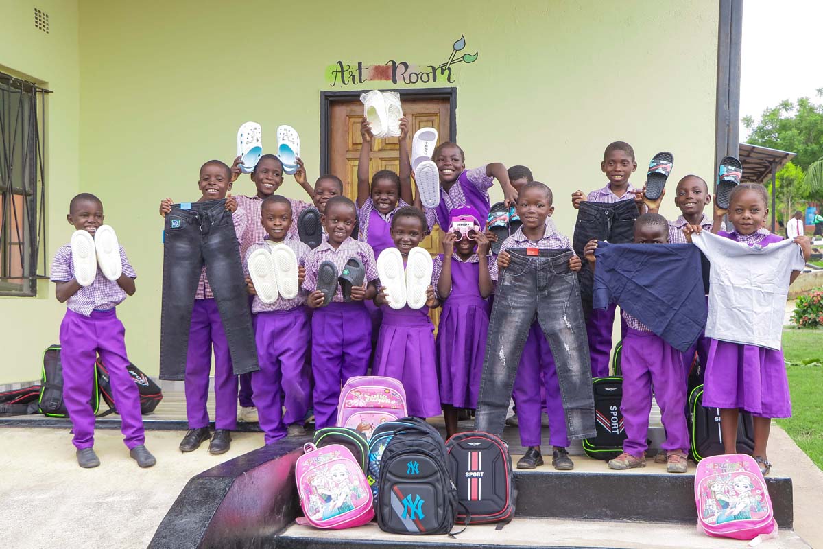 Children holding gifts and toys, smiling at the camera