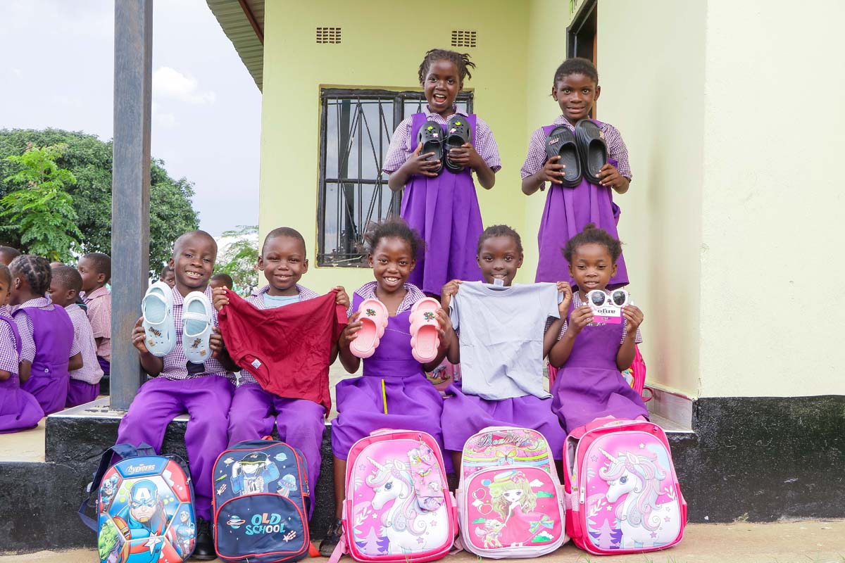 Children holding gifts and toys, smiling at the camera