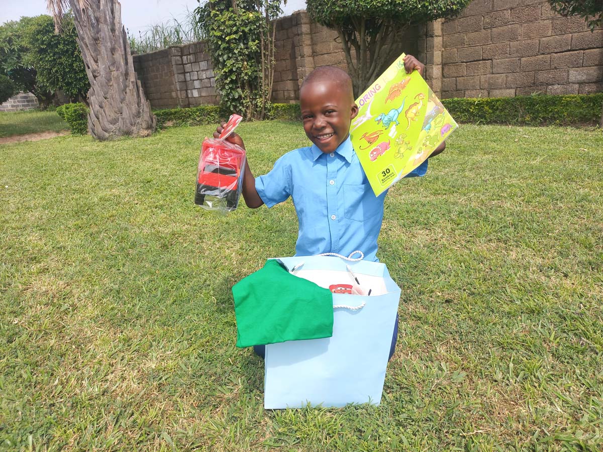Child holding up their hope packs gifts
