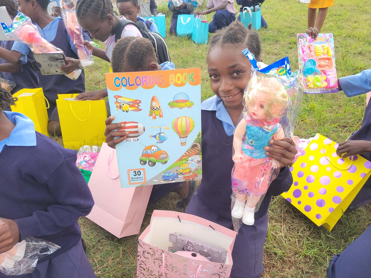 Children holding gifts and toys, smiling at the camera