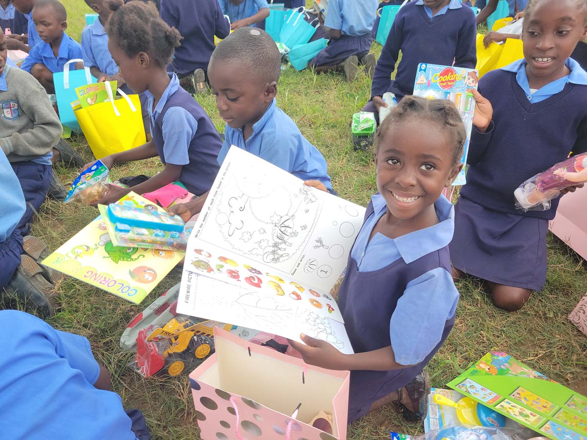 Children holding gifts and toys, smiling at the camera