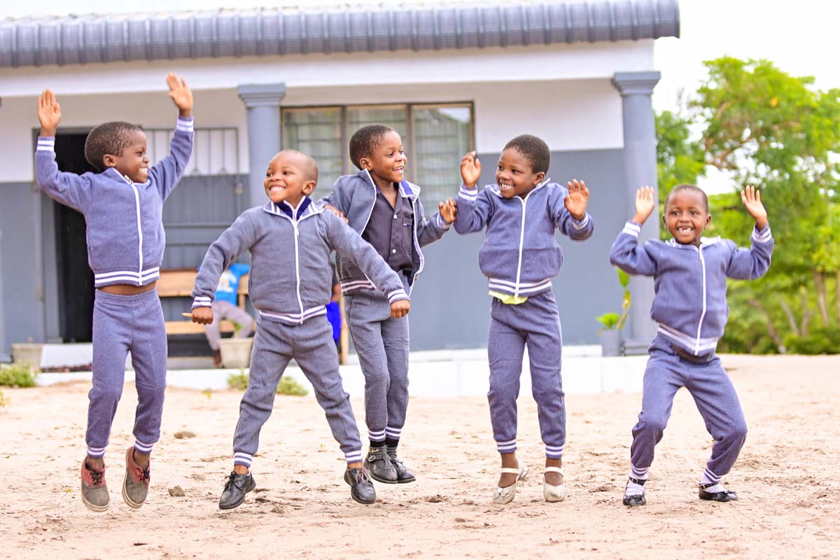 Five children smiling and jumping in excitement