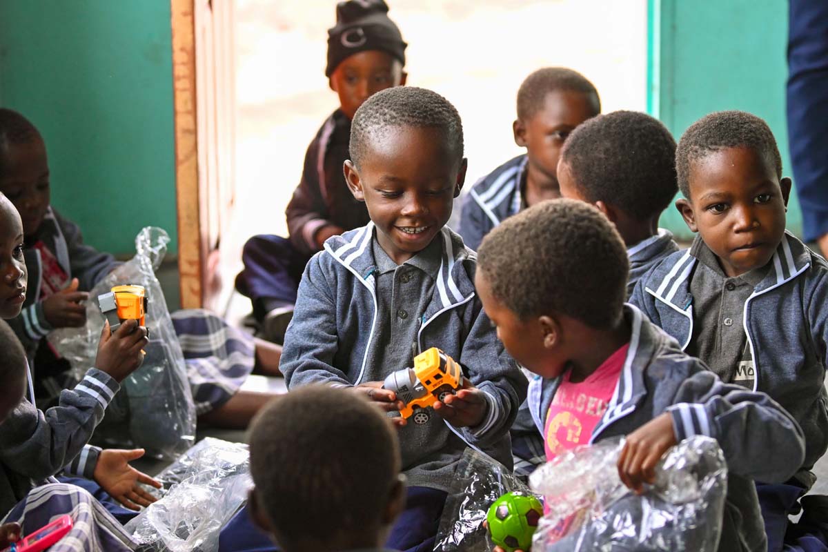 Children smiling and opening their hope packs gifts
