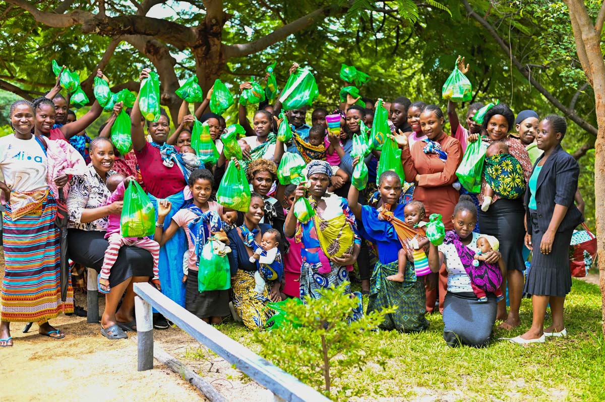 Group of caregivers holding up Hope Packs and smiling
