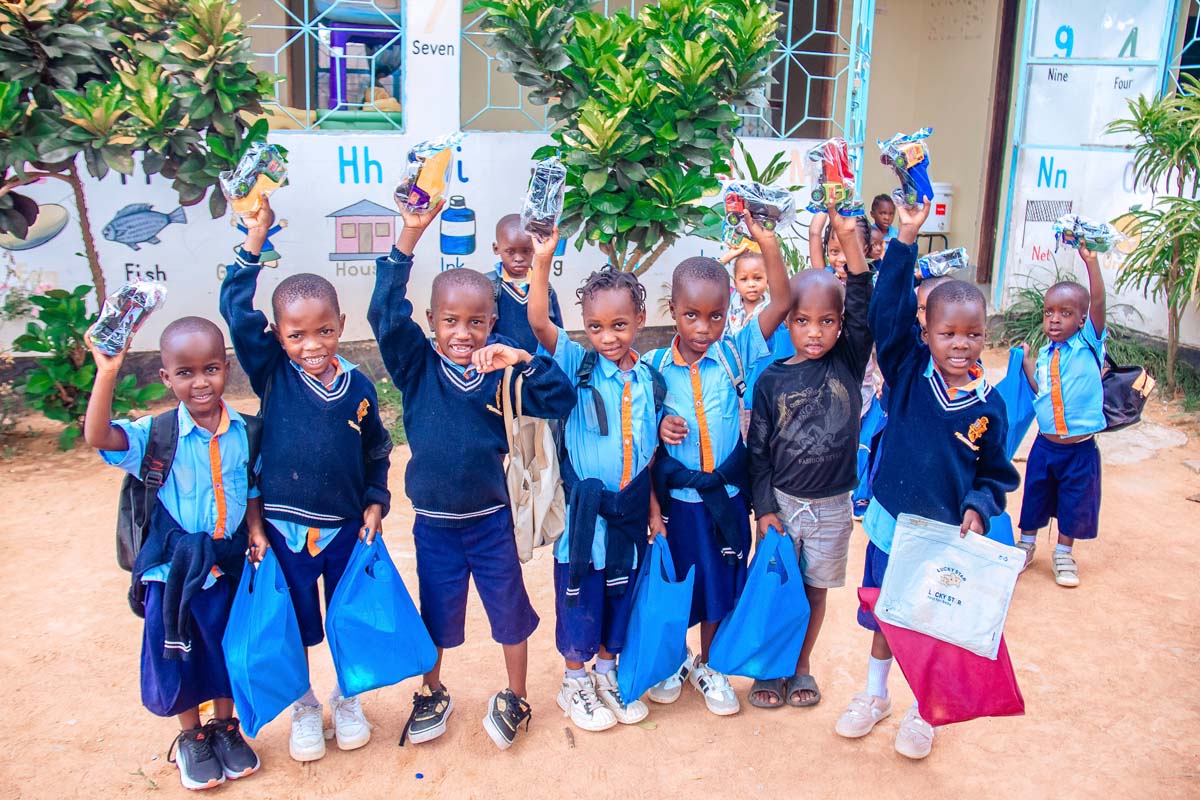 Children holding up gifts and smiling at camera