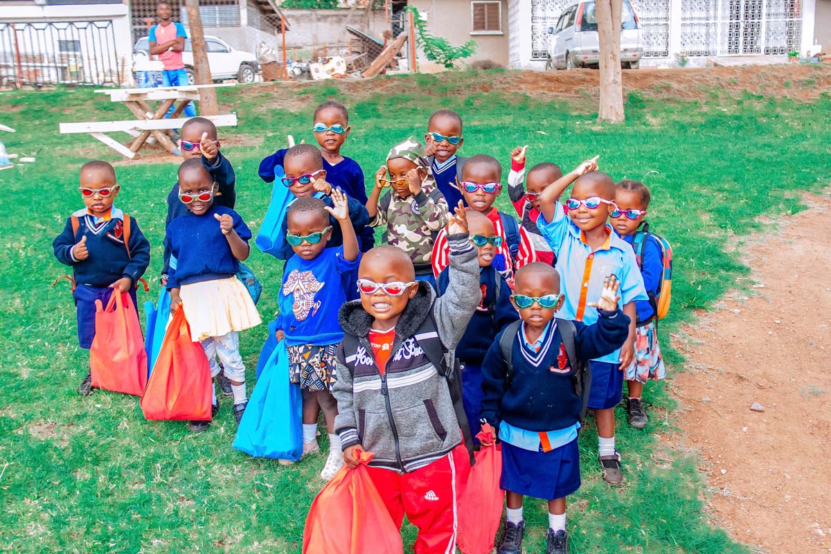 Children holding up gifts and smiling at camera