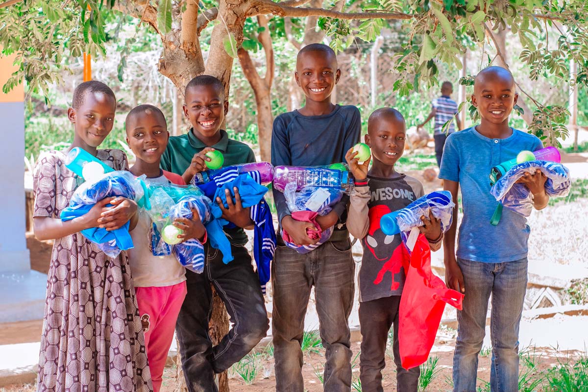 Children holding up gifts and smiling at camera