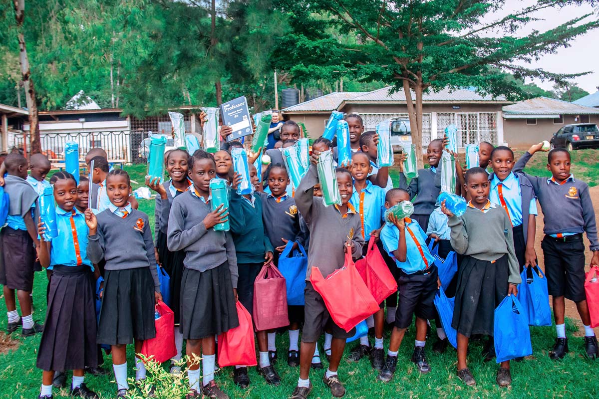 Children holding up gifts and smiling at camera