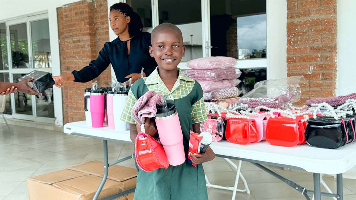 Child holding up gifts and smiling at camera