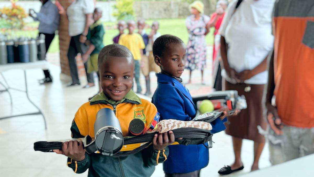 Child holding up gifts and smiling at camera