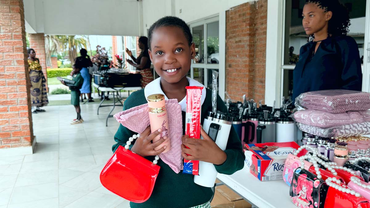 Child holding up gifts and smiling at camera